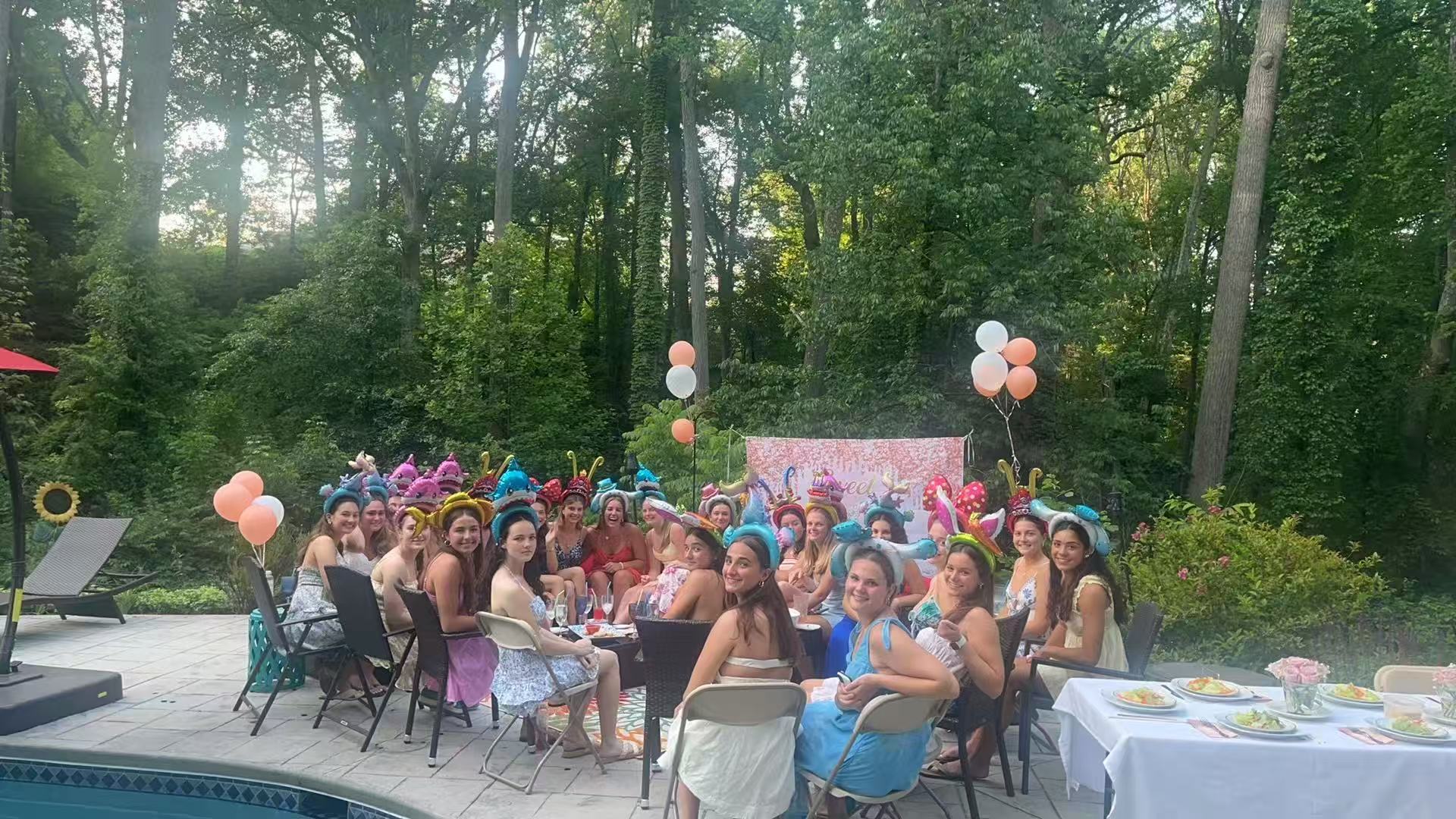 Pool party celebration with colorful headbands and balloons