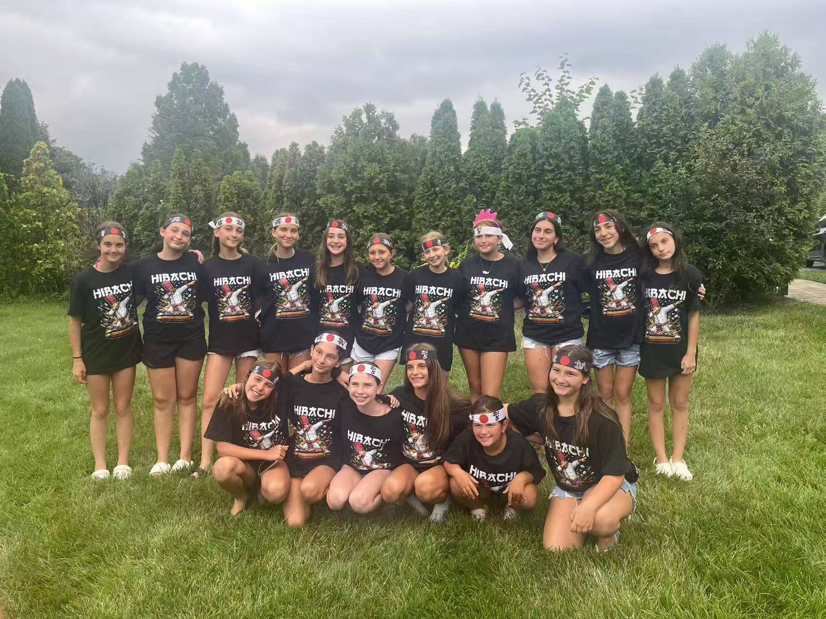 Kids in matching Hibachi t-shirts and Japanese headbands posing for a group photo